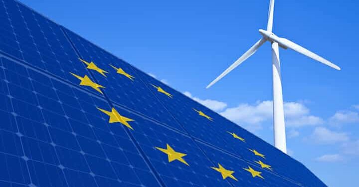 Picture of the European Union flag on solar panels and a wind turbine
