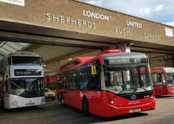 Picture of one of the first new electric buses leaving a bus garage in Shepherd's Bush.